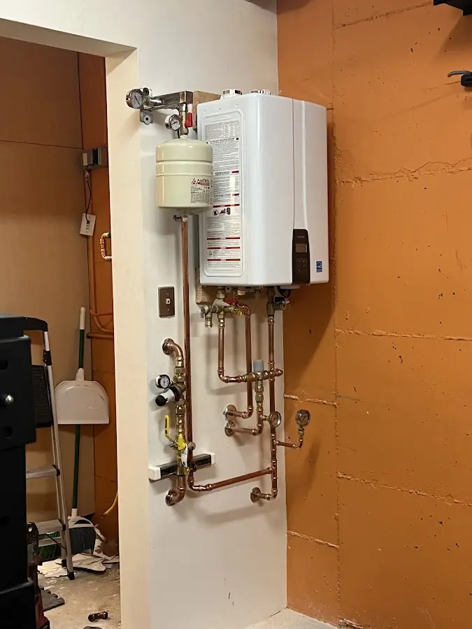 Plumbing technician inspecting water heater connections in Hesperia